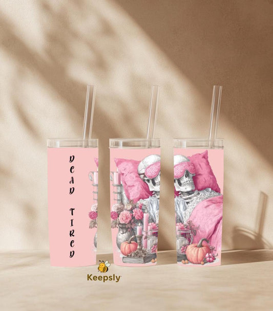 Pink skeleton tumbler with ‘DEAD TIRED’ text, cozy gothic design with pumpkins, flowers and candles on a soft beige background