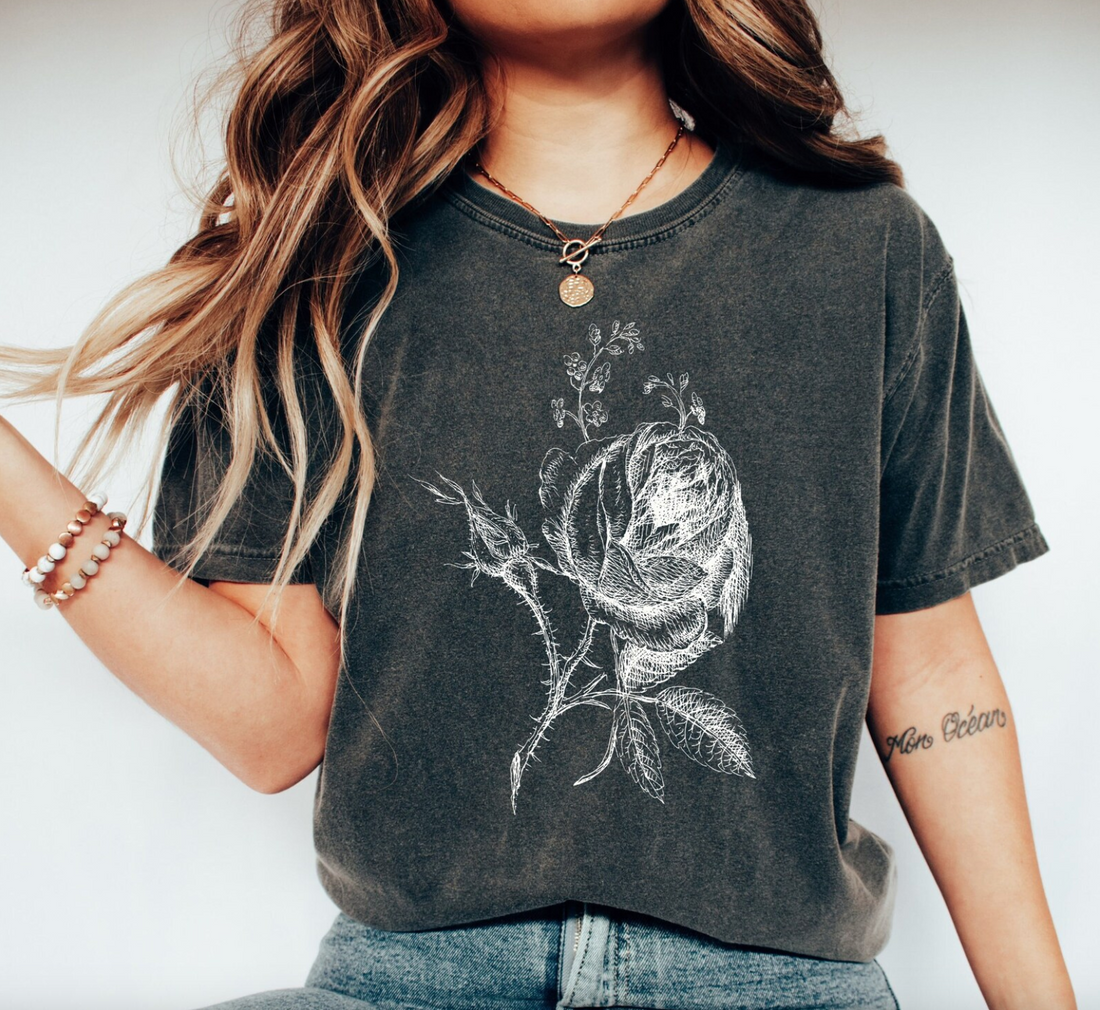 Graphic t-shirt featuring a beautiful rose design, symbolizing June's birth flower, perfect for adding a touch of floral elegance to any outfit.