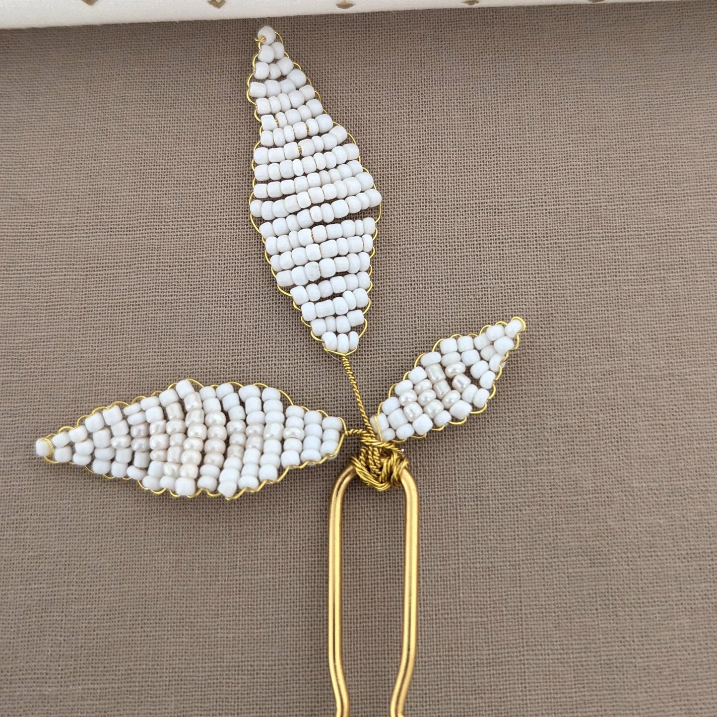 Elegant gold wire hairpin with white bead leaves, perfect for updos or wearing hair down.