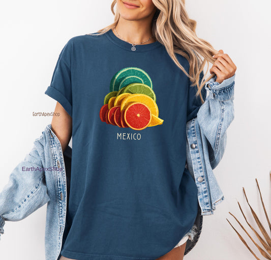 A woman is wearing a midnight blue Comfort colors shirt with a tropical citrus Mexico graphic