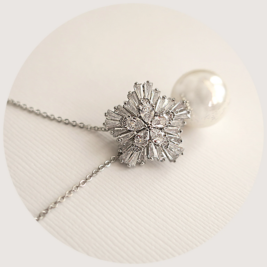 Elegant white ivory pearl drop and cubic zirconia snowflake necklace with a silver finish and adjustable chain, perfect for bridal and formal occasions